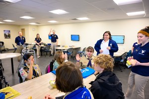 Women In Science and Health Committee help Scouts earn merit badges during the annual Merit Badge University event.