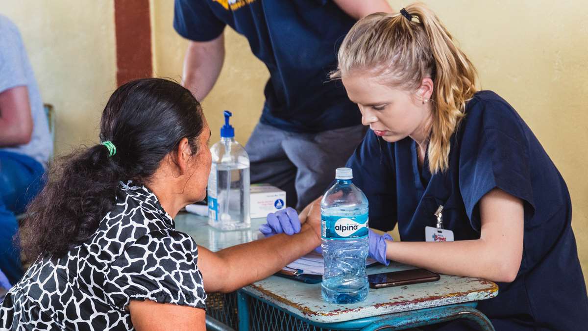 A WVU student examines a patient.